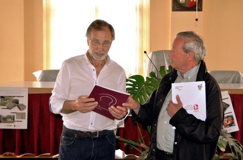 El alcalde de La Ercina, Ignacio Robles, y el presidente de Promonumenta, Marcelino Fernández, intercambian sus respectivas publicaciones.